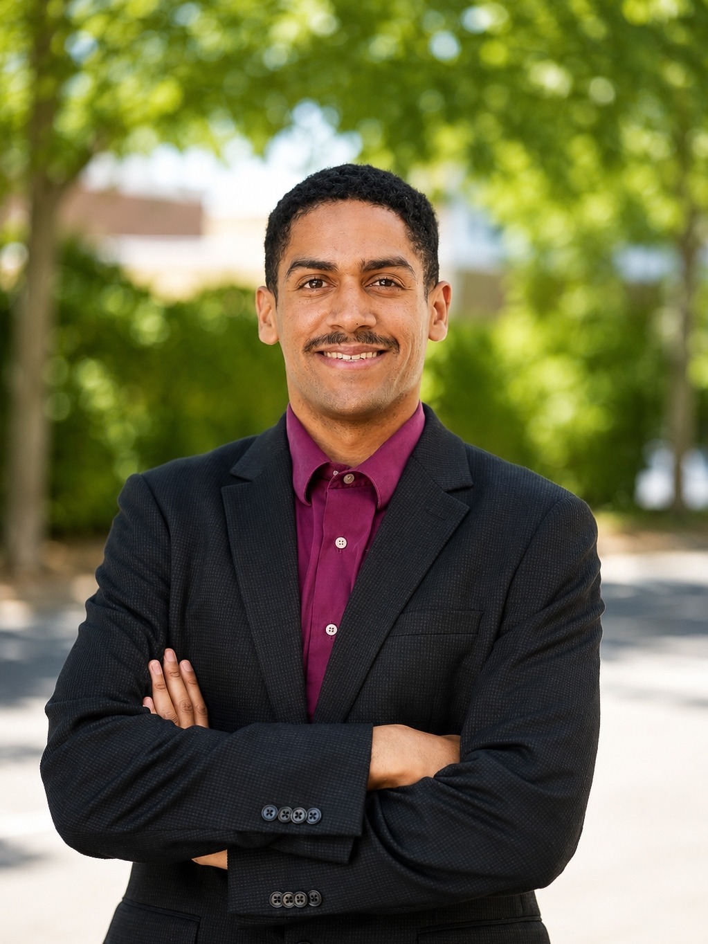 Solomon Stovall-Ceja, REALTOR®, standing outdoors in a dark blazer